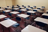An indoor view of a modern, clean classroom with rows of empty desks and chairs.